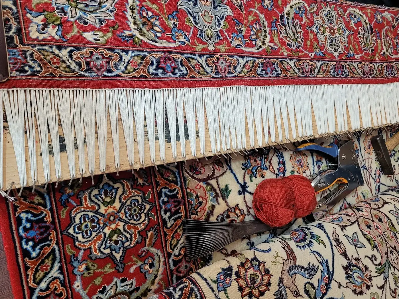 Bordo e frange di un tappeto fissati al telaio durante il restauro